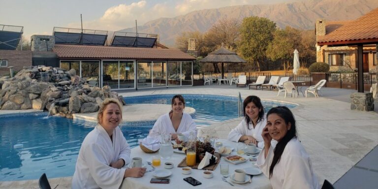Amigas con bata y merienda junto a la piscina del spa