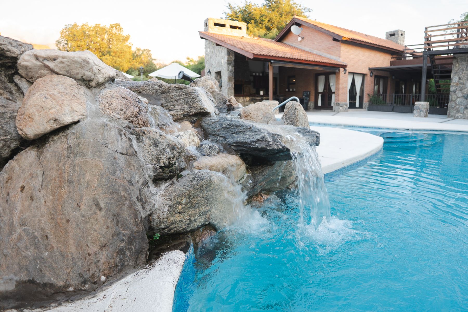 Piscina con cascada en complejo de cabañas