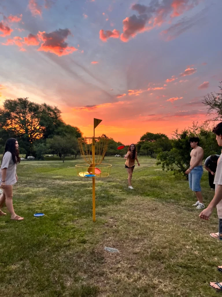 Partido de frisbee golf al atardecer en el parque