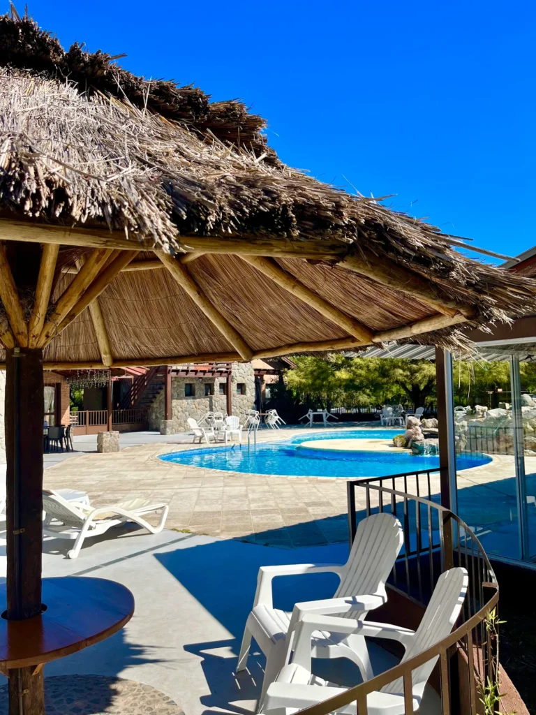 Pileta exterior con palapa y vista a las sierras