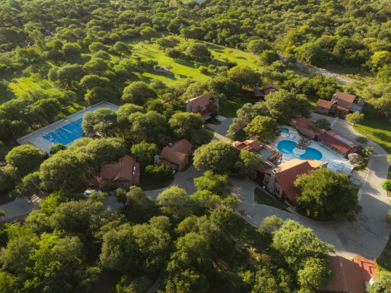 Vista aérea de las piletas de La Quinta Resort entre los árboles, en Merlo