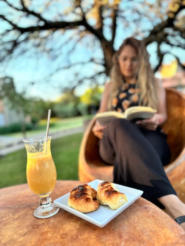Huésped leyendo con un jugo en el parque de La Quinta Resort